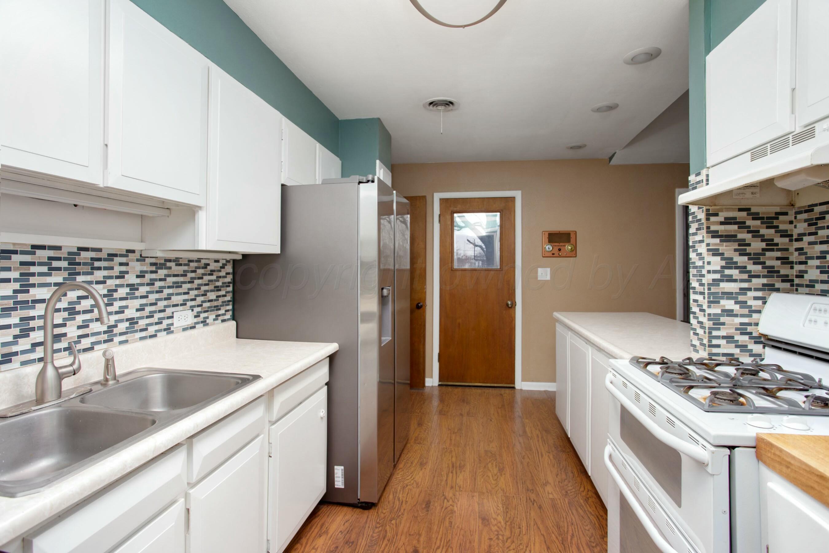 3621 Thurman Street Amarillo, TX 79109 - Photo 11 of 29 a kitchen with a sink stove and refrigerator