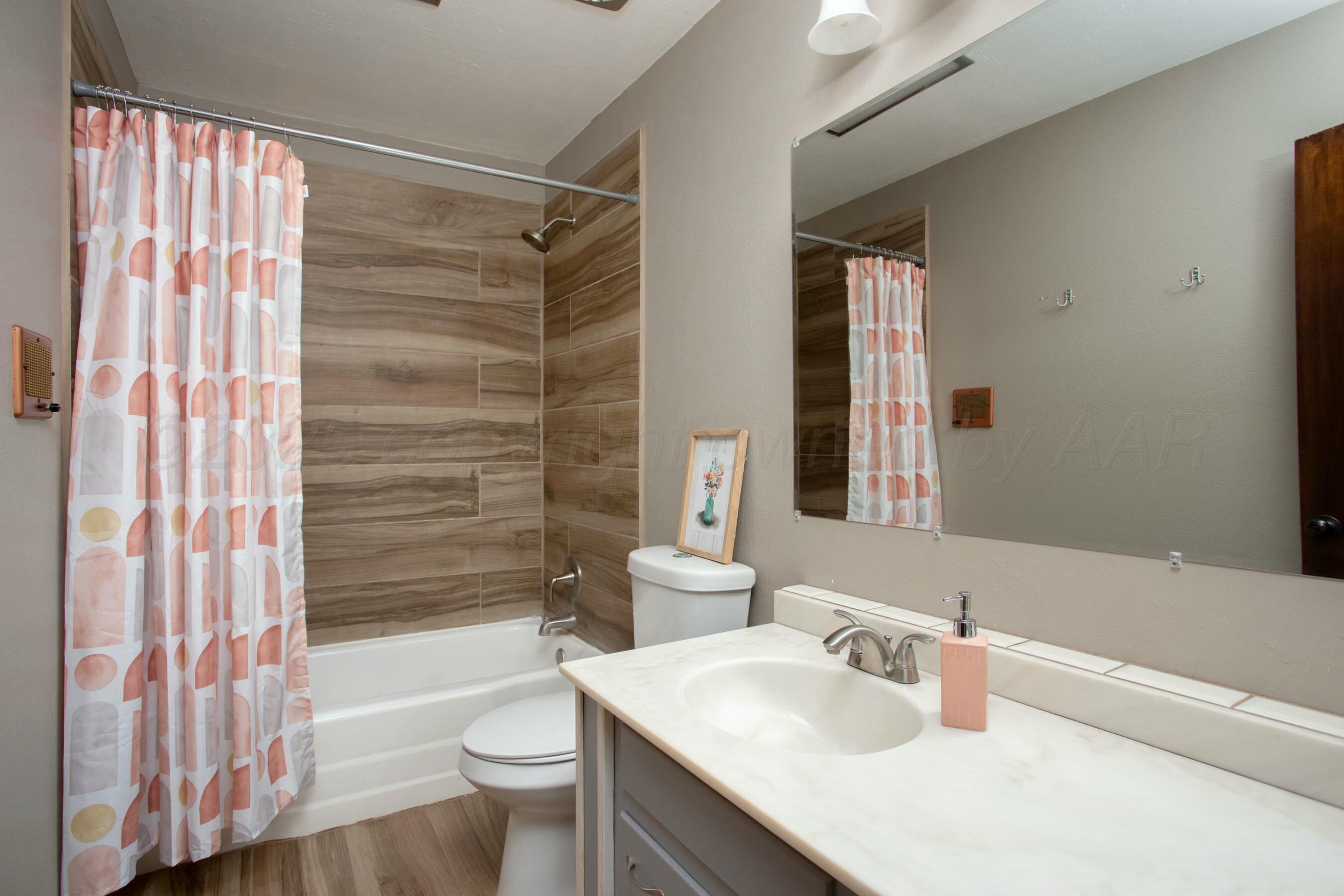 3621 Thurman Street Amarillo, TX 79109 - Photo 17 of 29 a bathroom with a sink a toilet and shower curtain