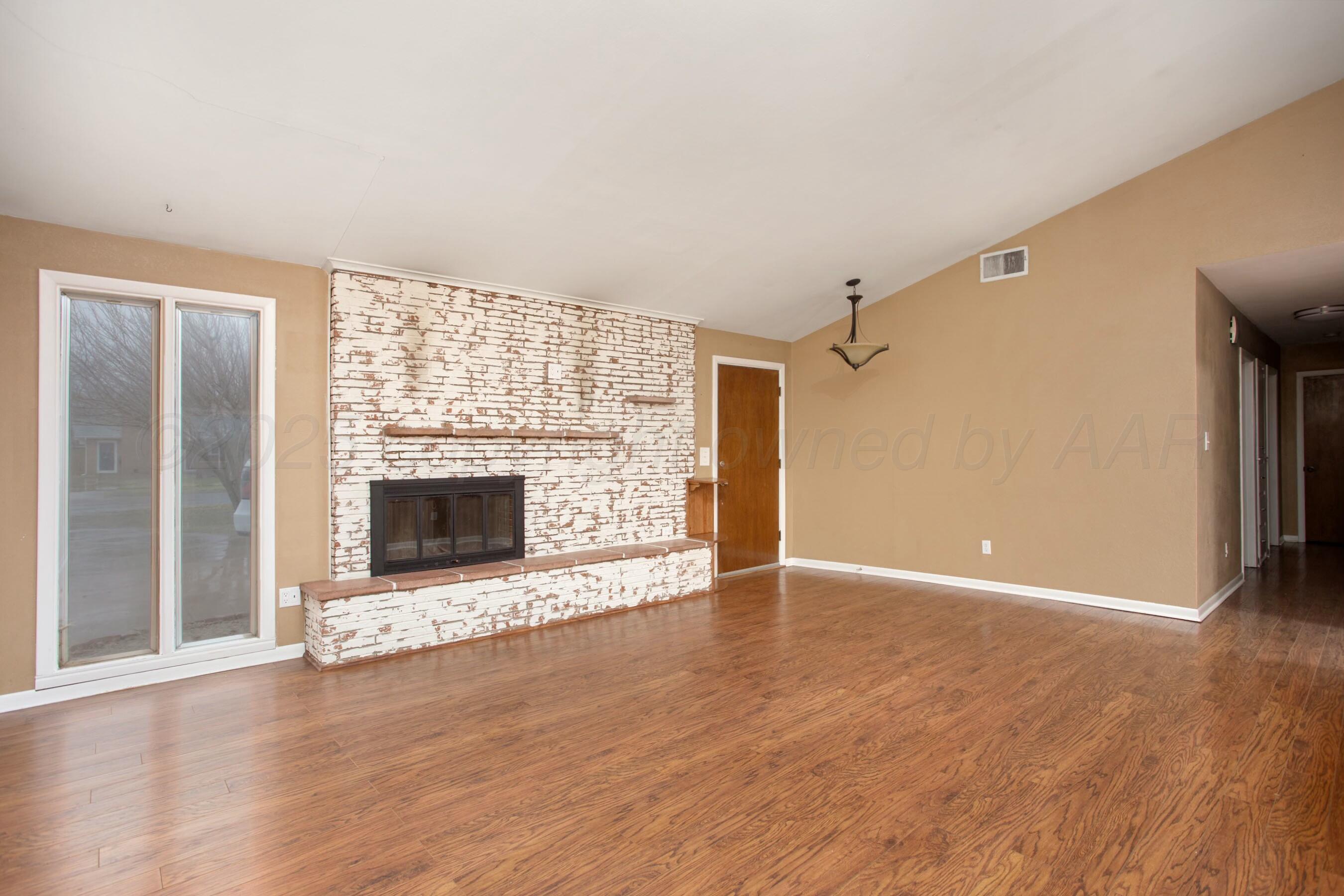 3621 Thurman Street Amarillo, TX 79109 - Photo 3 of 29 a view of an empty room with a fireplace and a window