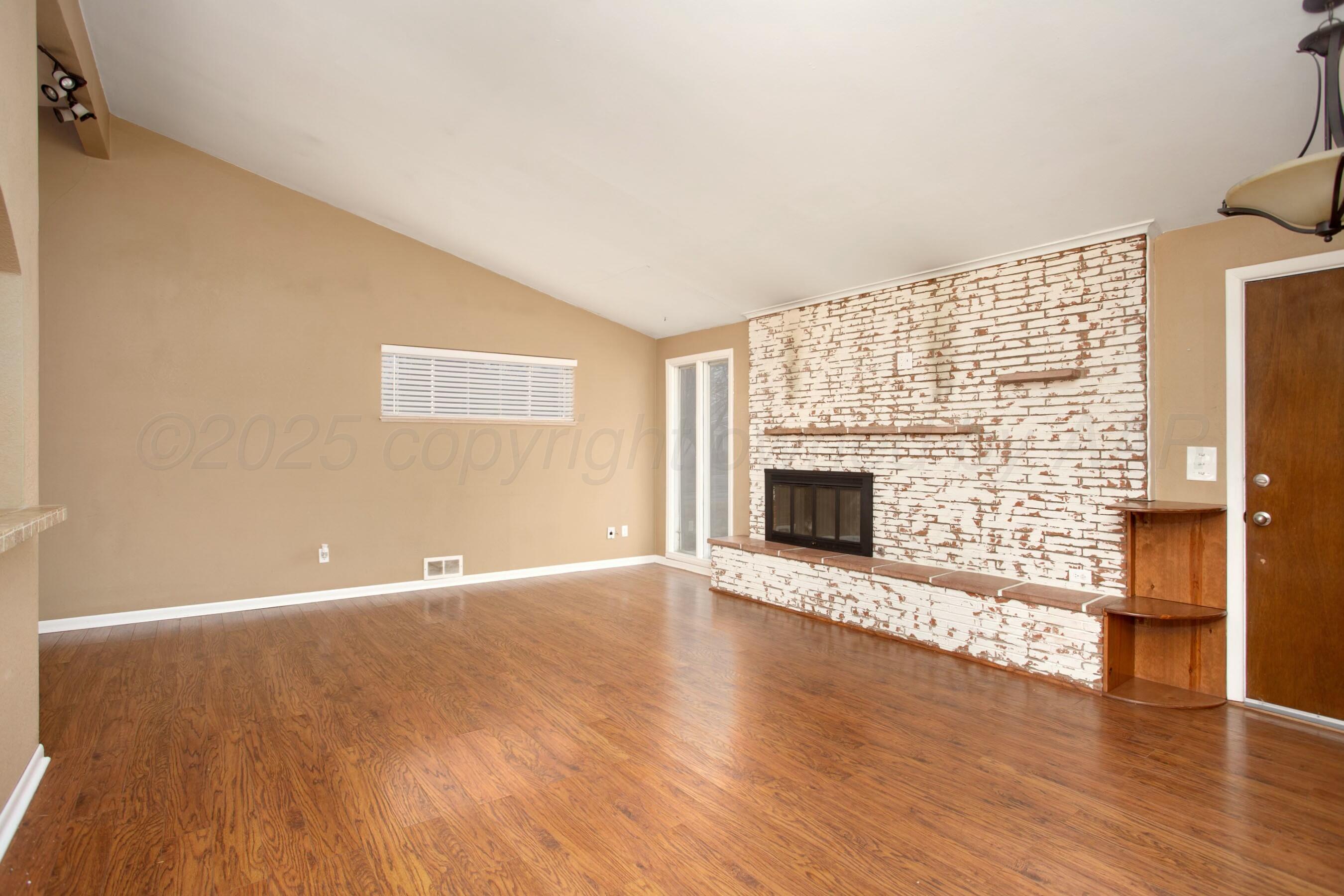 3621 Thurman Street Amarillo, TX 79109 - Photo 4 of 29 a view of an empty room with a fireplace and wooden floor