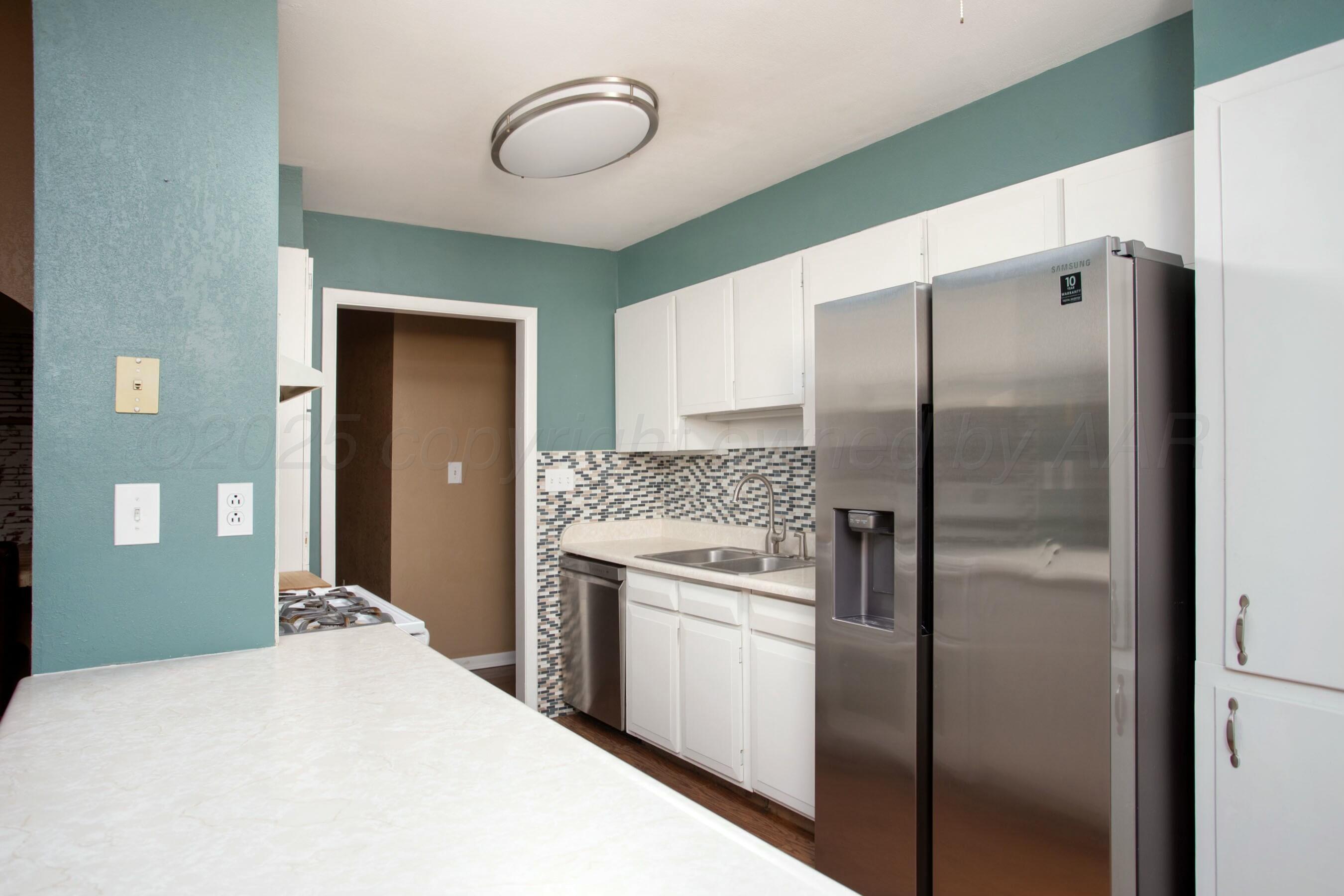 3621 Thurman Street Amarillo, TX 79109 - Photo 9 of 29 a kitchen with a refrigerator and a sink