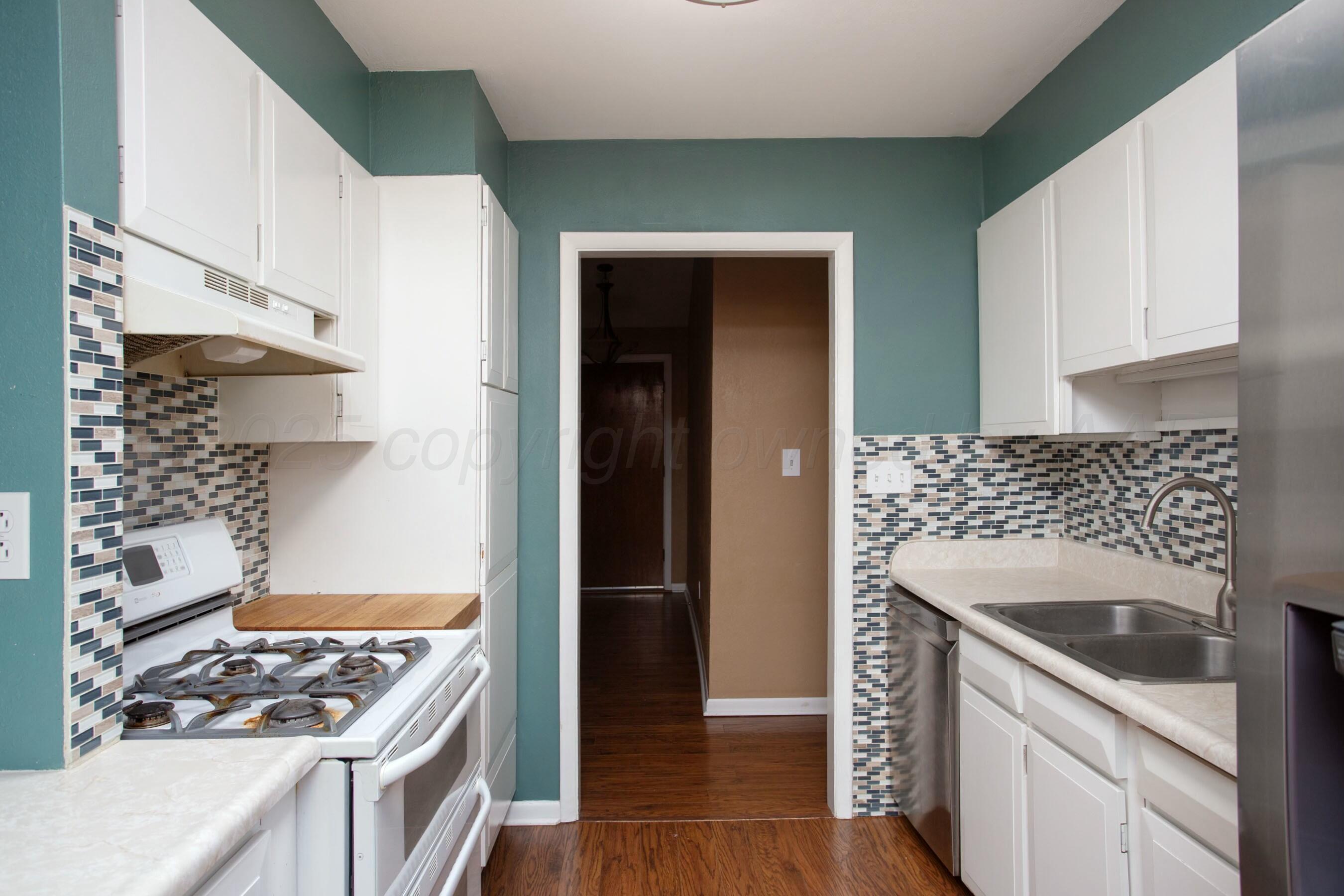 3621 Thurman Street Amarillo, TX 79109 - Photo 10 of 29 a kitchen with granite countertop a stove and a refrigerator
