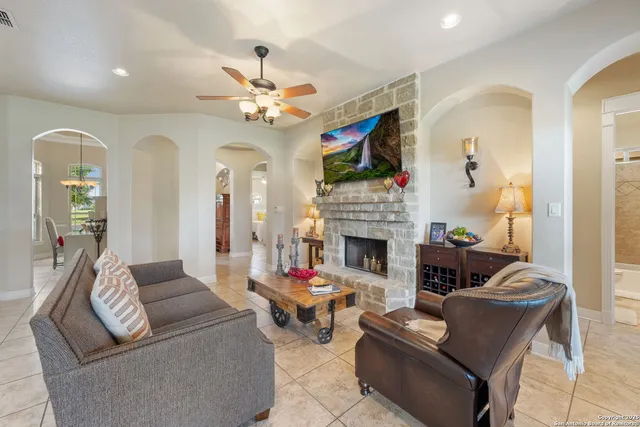 a living room with furniture a fireplace and a flat screen tv