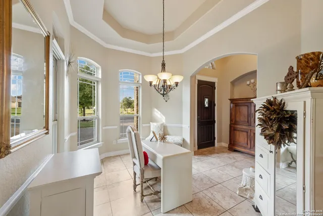 a living room with furniture a chandelier and a flat screen tv