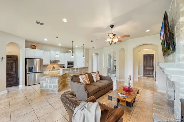 a living room with furniture a fireplace and a chandelier