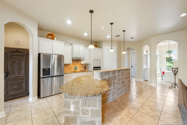 a kitchen with kitchen island a counter top space cabinets stainless steel appliances and a ceiling fan