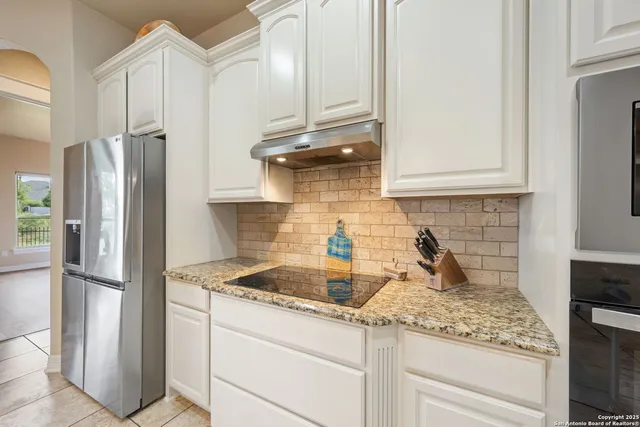 a kitchen with stainless steel appliances granite countertop a refrigerator and a sink