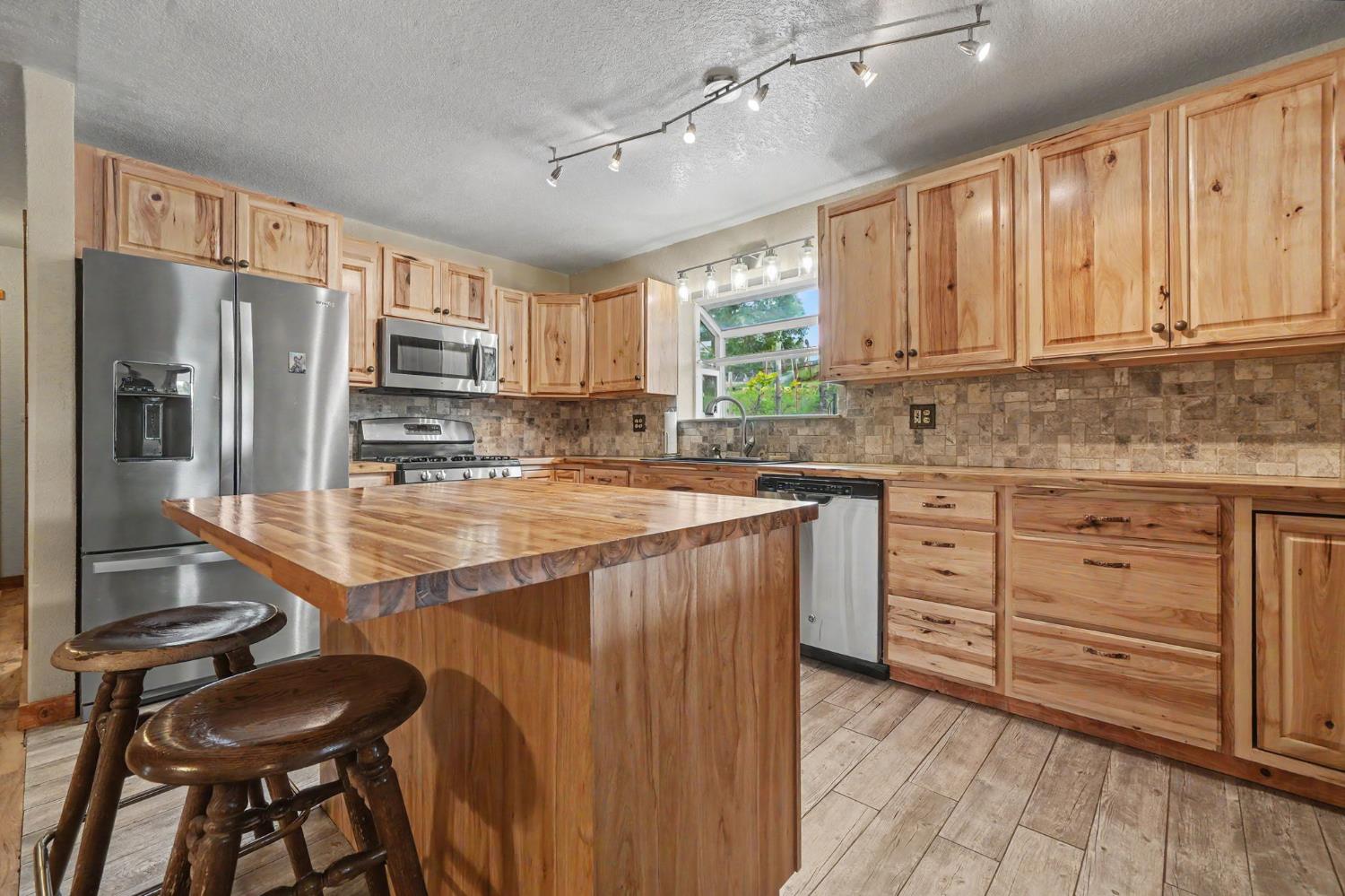 4821 Old Emigrant Trail East Mountain Ranch, CA 95246 - Photo 16 of 65 a kitchen with stainless steel appliances kitchen island granite countertop a stove refrigerator and cabinets
