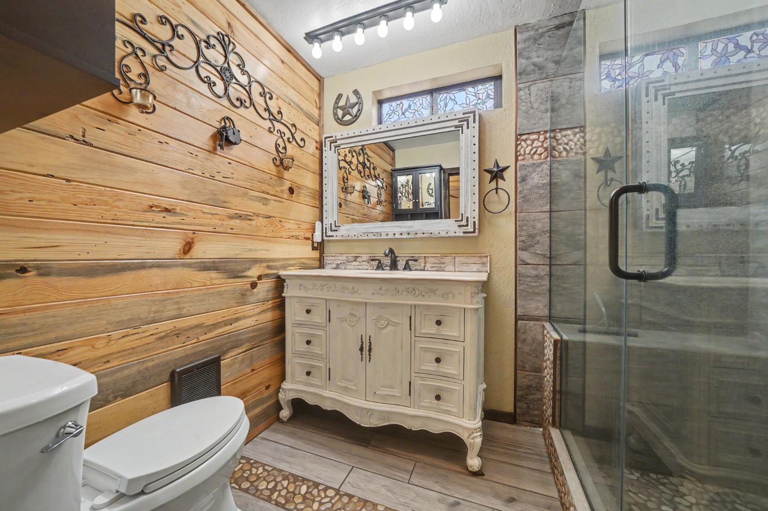 4821 Old Emigrant Trail East Mountain Ranch, CA 95246 - Photo 26 of 65 a bathroom with a granite countertop toilet sink and shower