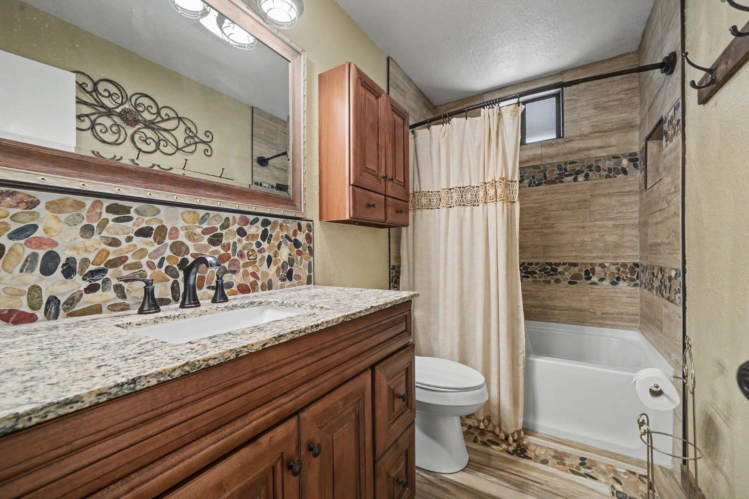 4821 Old Emigrant Trail East Mountain Ranch, CA 95246 - Photo 32 of 65 a bathroom with a granite countertop sink toilet and shower