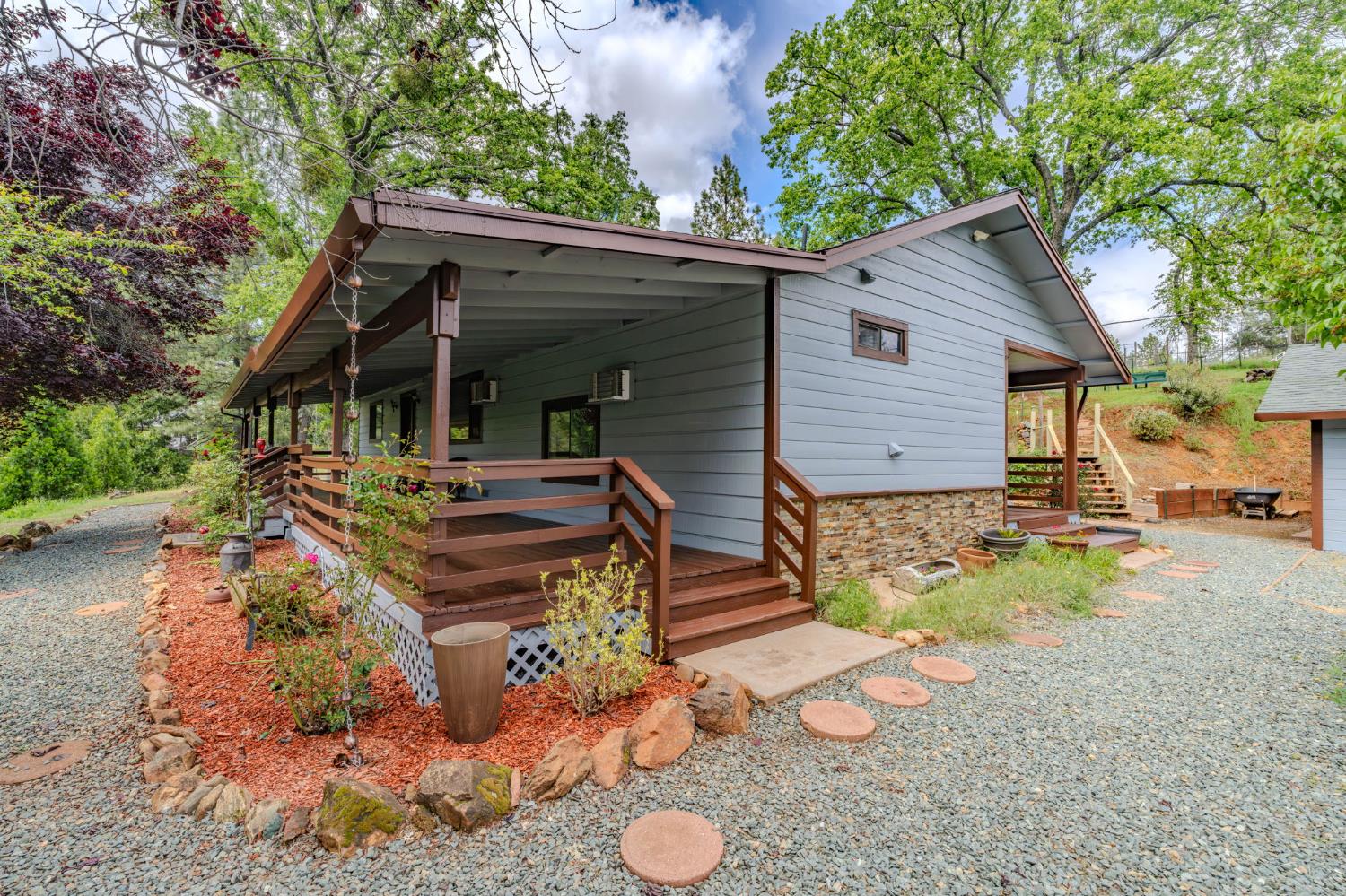 4821 Old Emigrant Trail East Mountain Ranch, CA 95246 - Photo 5 of 65 a view of a house with backyard outdoor seating area and covered with trees