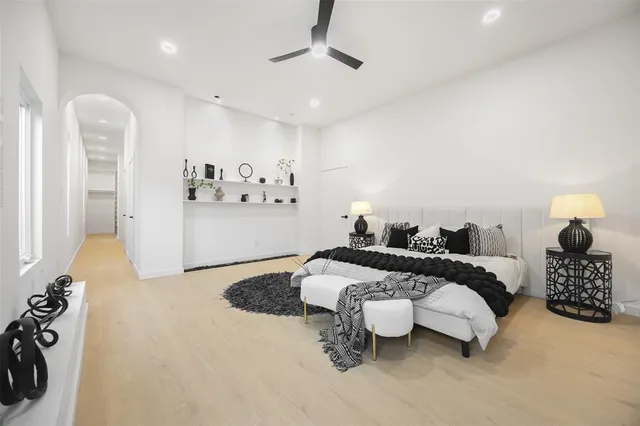 a spacious bedroom with a bed and a chandelier