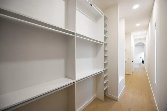 a view of a hallway with wooden floor and a chandelier