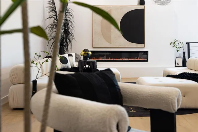 a room with a fireplace and potted plant