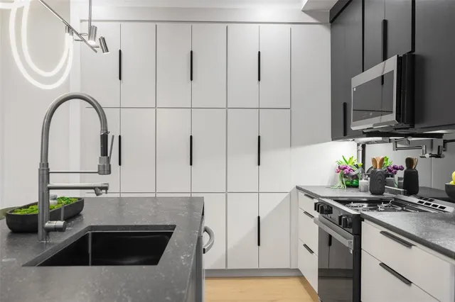 a kitchen with stainless steel appliances granite countertop a sink a stove and a refrigerator