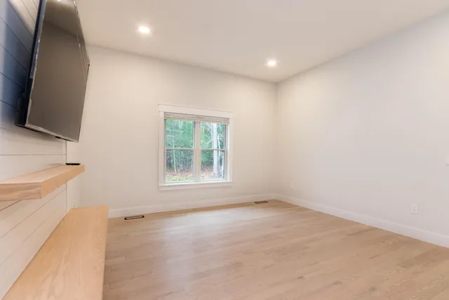 an empty room with windows and flat screen tv