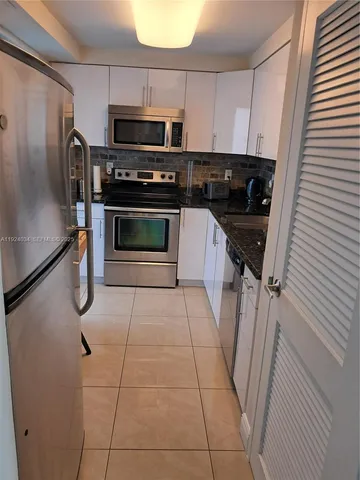 a kitchen with stainless steel appliances a stove a microwave and a refrigerator