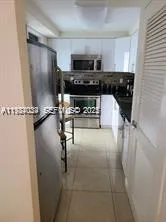 a kitchen with a refrigerator and a stove top oven