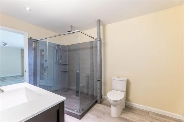 a bathroom with a sink a toilet and shower