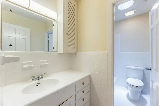 a bathroom with a toilet a sink and mirror
