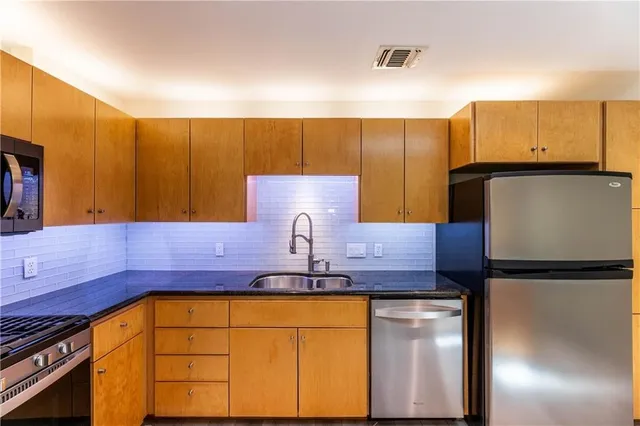 a kitchen with stainless steel appliances granite countertop a sink and cabinets