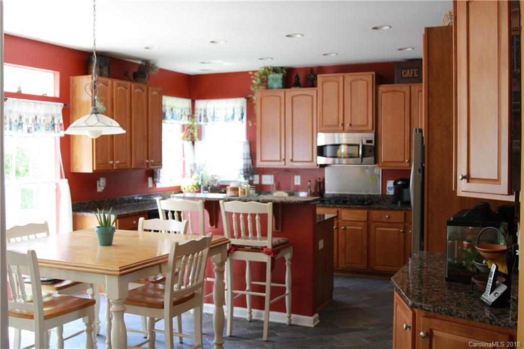 285 Choate Avenue Fort Mill, SC 29708 - Photo 8 of 24 a kitchen with stainless steel appliances granite countertop a stove top oven a sink dishwasher and a dining table with cabinets