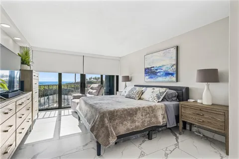 a bedroom with a large bed and a flat tv screen on the dresser