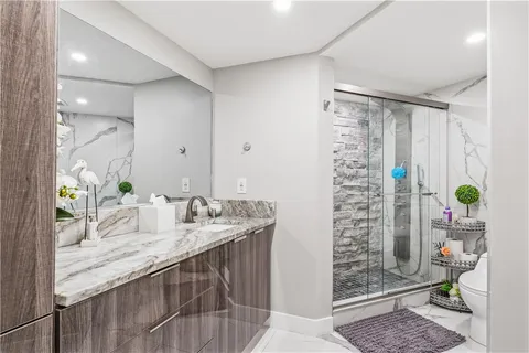 a bathroom with a granite countertop sink a toilet and shower