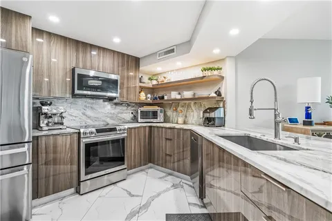 a kitchen with stainless steel appliances granite countertop a sink refrigerator and microwave