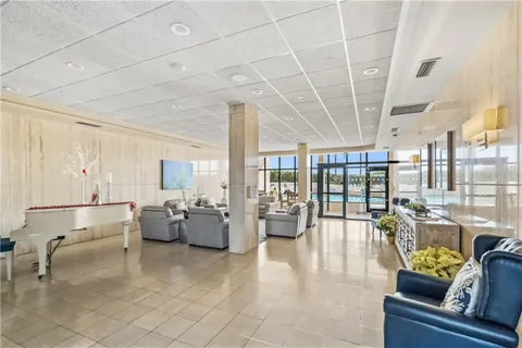 a living room with furniture and floor to ceiling windows