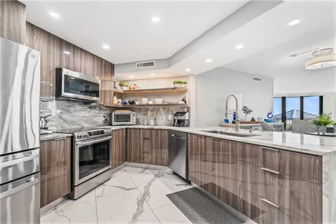 a kitchen with stainless steel appliances kitchen island granite countertop a stove sink and microwave