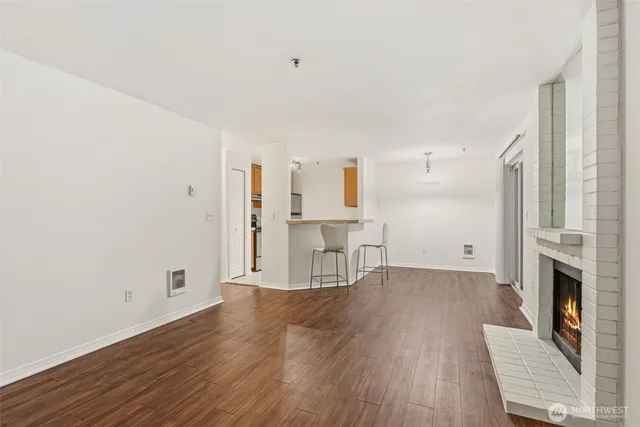 a view of empty room with wooden floor and fireplace