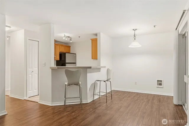 a view of a kitchen with wooden floor and electronic appliances