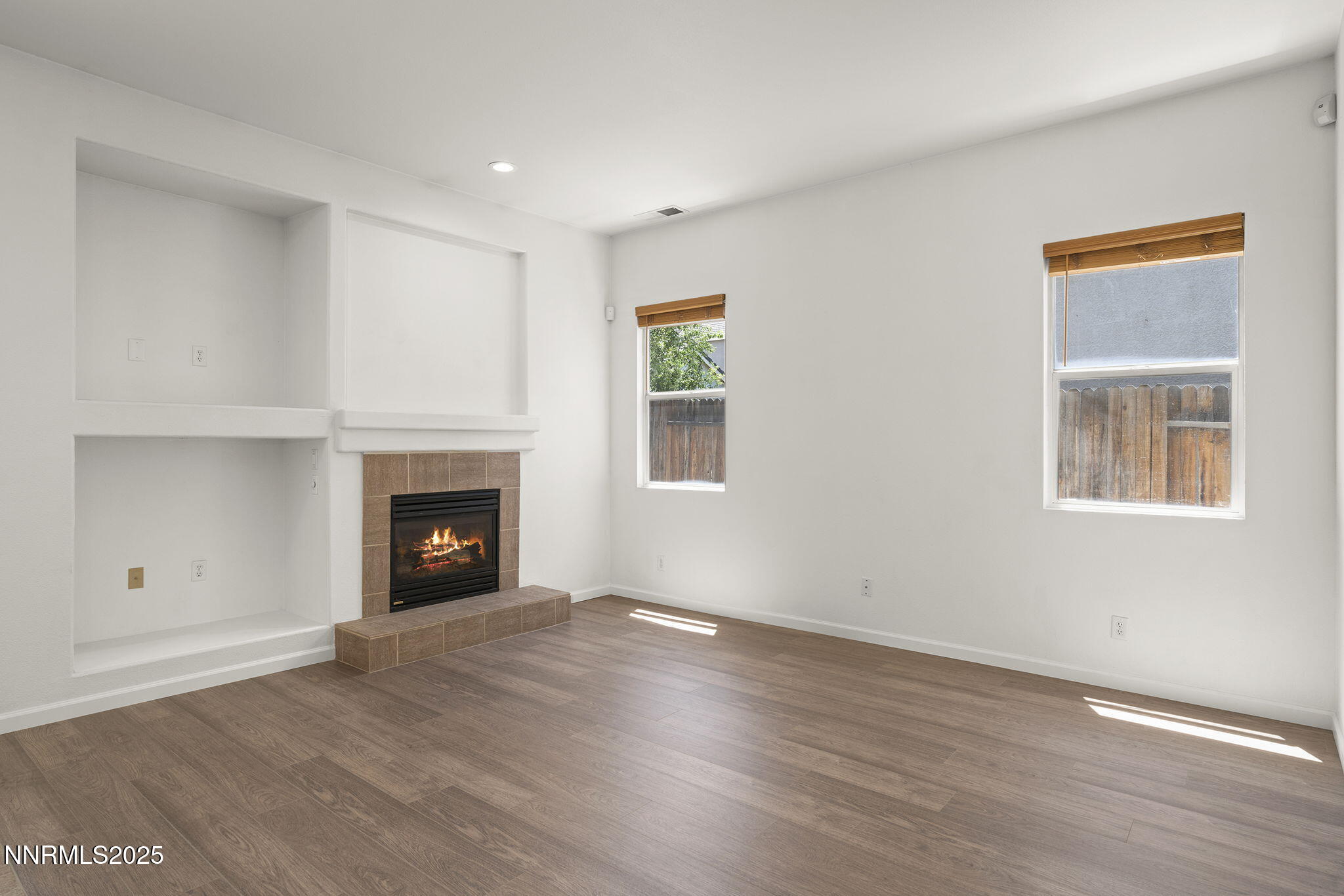 10452 Copper Wood Court Reno, NV 89521 - Photo 12 of 30 a view of an empty room with wooden floor fireplace and a window