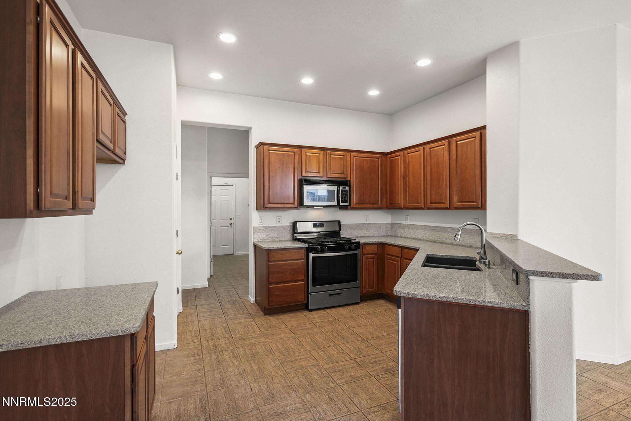 10452 Copper Wood Court Reno, NV 89521 - Photo 16 of 30 a kitchen with stainless steel appliances granite countertop wooden cabinets a stove top oven a sink and dishwasher