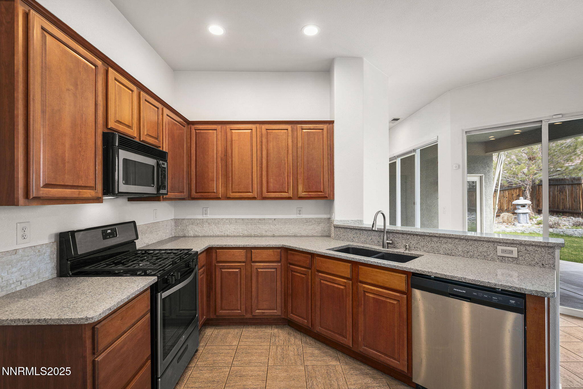 10452 Copper Wood Court Reno, NV 89521 - Photo 17 of 30 a kitchen with stainless steel appliances granite countertop a sink stove and microwave