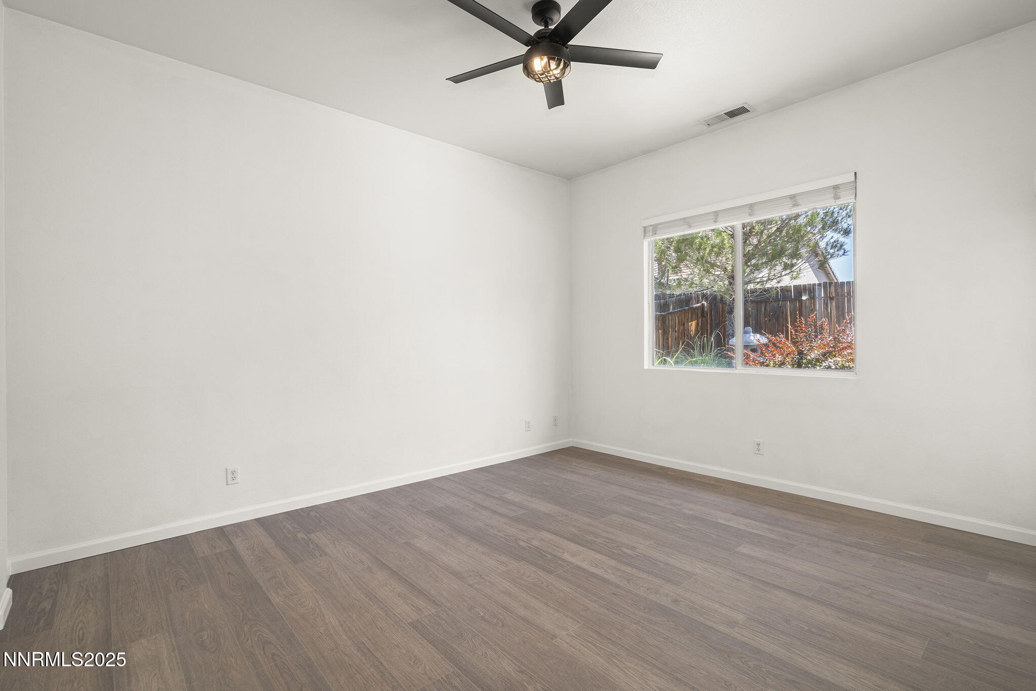 10452 Copper Wood Court Reno, NV 89521 - Photo 19 of 30 an empty room with wooden floor ceiling fan and windows