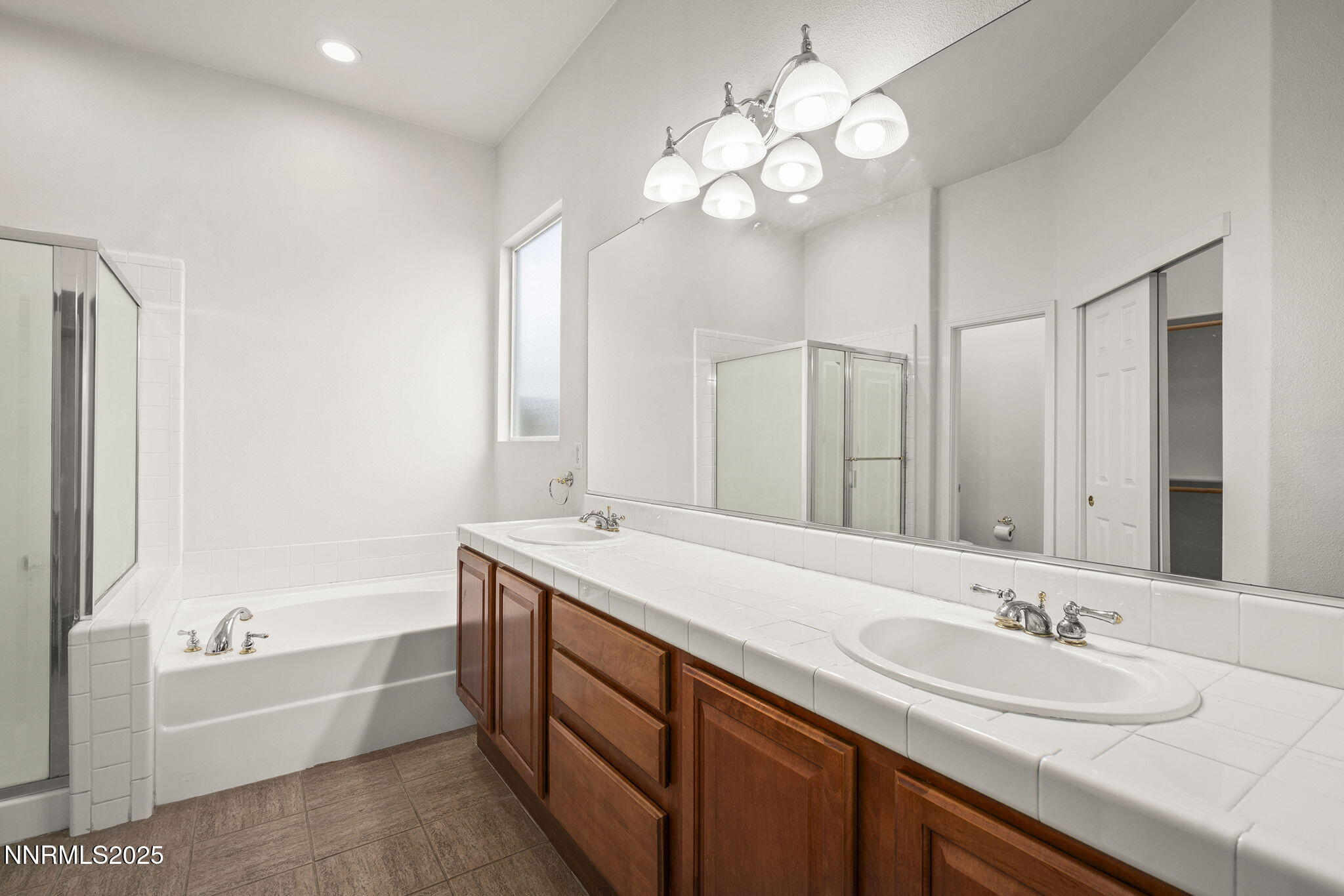 10452 Copper Wood Court Reno, NV 89521 - Photo 22 of 30 a bathroom with a granite countertop sink double vanity granite tub and a mirror