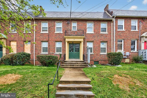 a front view of a brick house with a yard