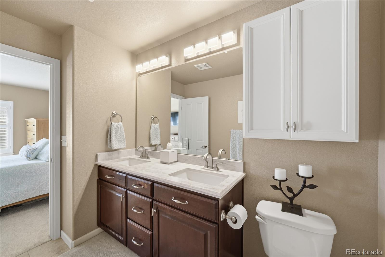 950 Elmhurst Drive, Unit C Highlands Ranch, CO 80129 - Photo 17 of 31 a bathroom with a toilet a sink and mirror