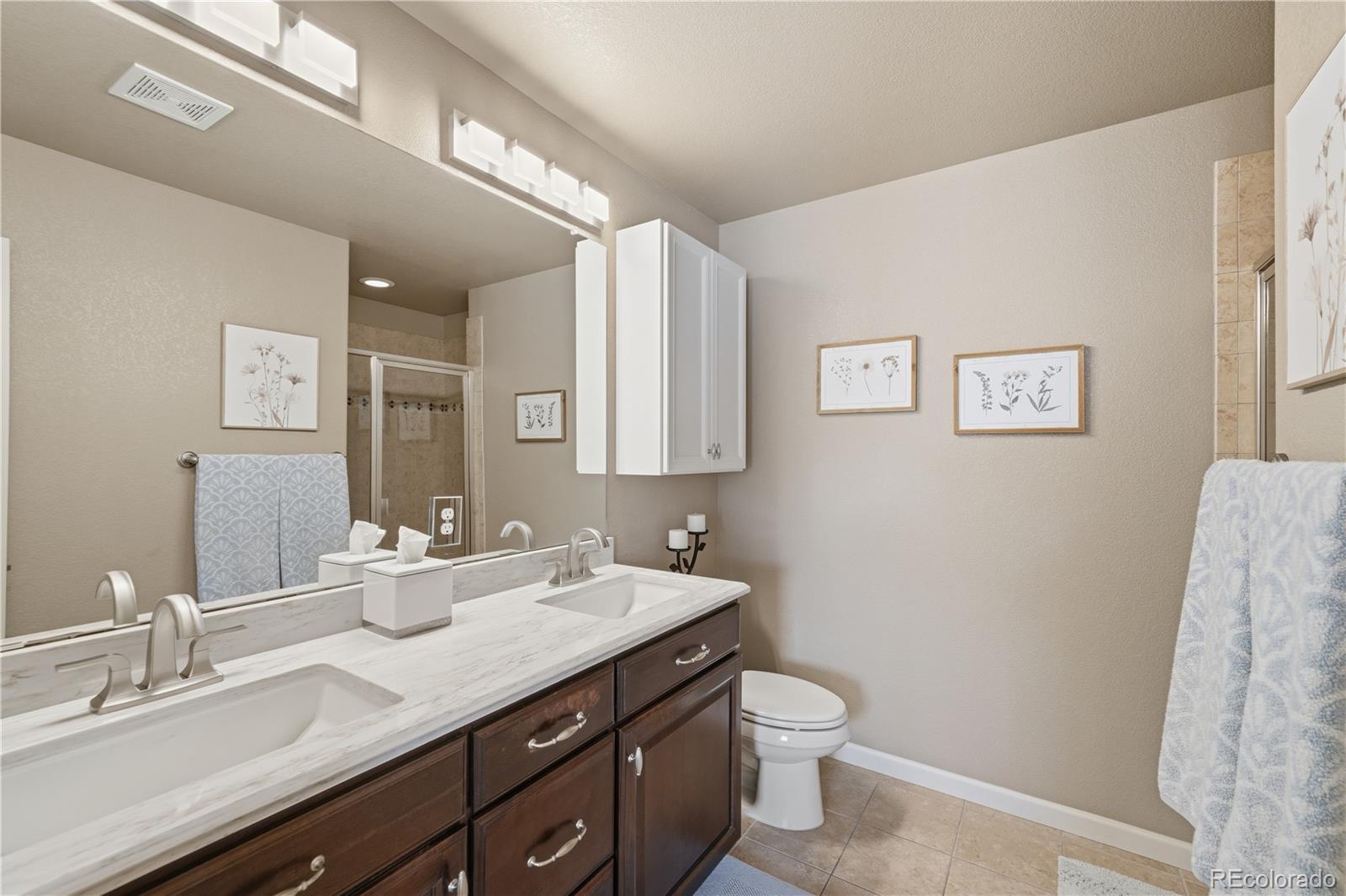 950 Elmhurst Drive, Unit C Highlands Ranch, CO 80129 - Photo 18 of 31 a bathroom with a granite countertop toilet sink and mirror