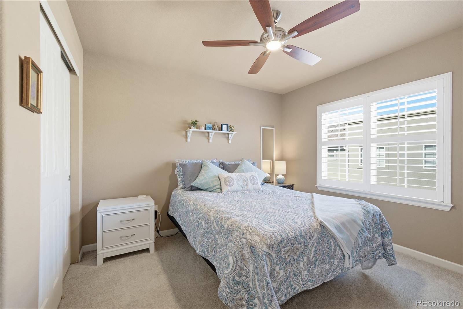 950 Elmhurst Drive, Unit C Highlands Ranch, CO 80129 - Photo 21 of 31 a bedroom with a bed a couch and a large window