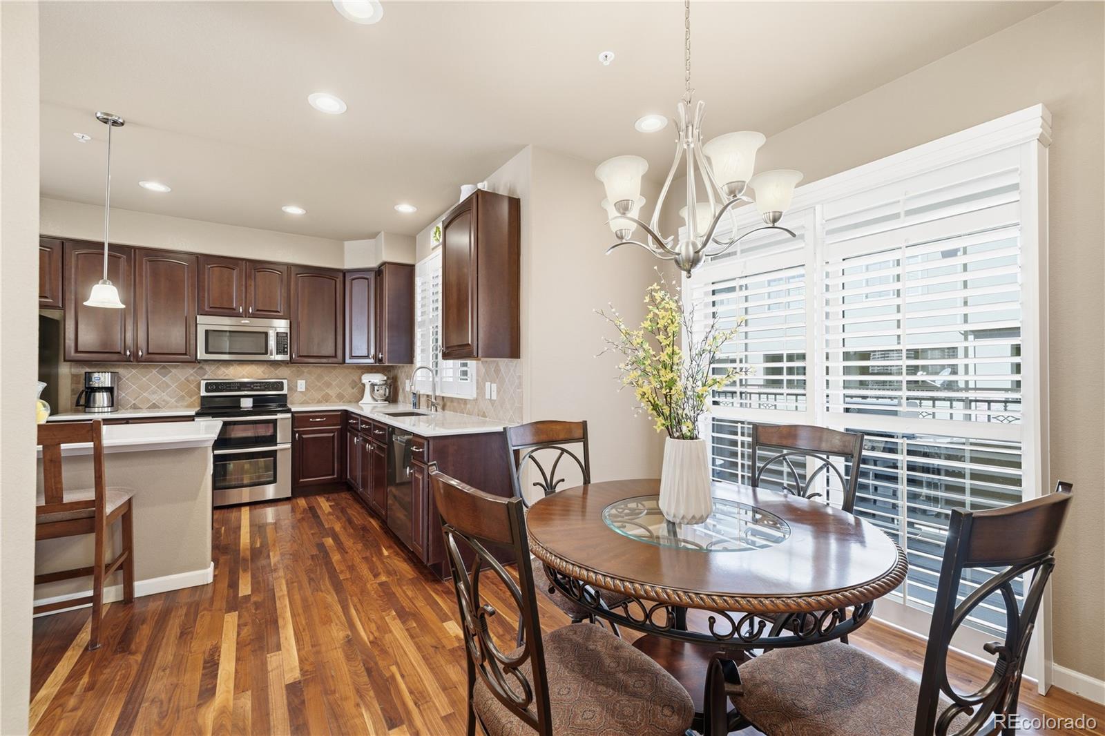 950 Elmhurst Drive, Unit C Highlands Ranch, CO 80129 - Photo 9 of 31 a kitchen with granite countertop a stove a sink a dining table and chairs