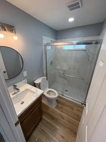 a bathroom with a granite countertop sink toilet and shower
