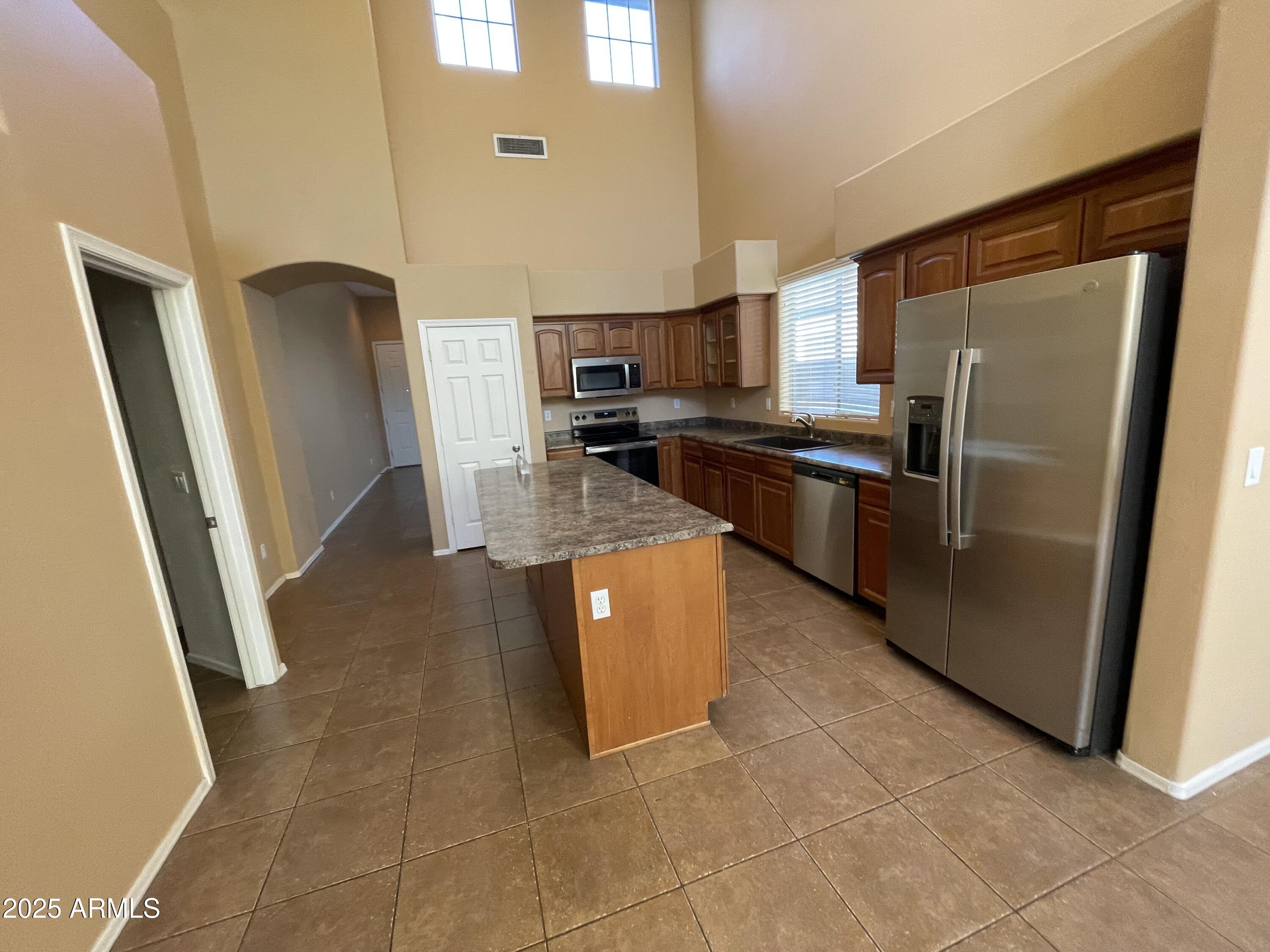 1441 East Thornton Avenue Gilbert, AZ 85297 - Photo 6 of 13 a kitchen with stainless steel appliances granite countertop a refrigerator a stove and a sink