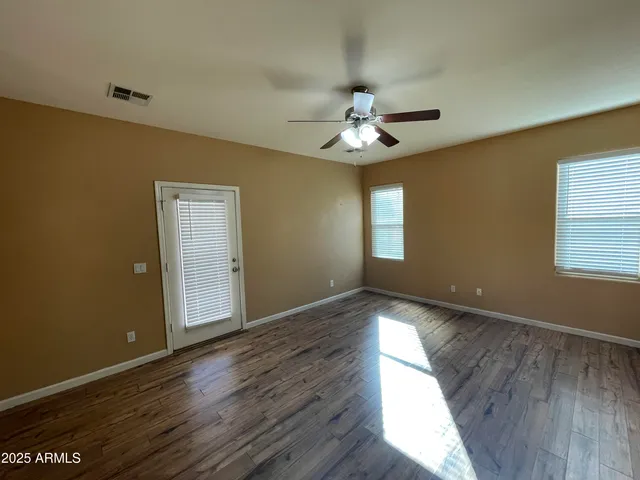 a view of an empty room with wooden floor