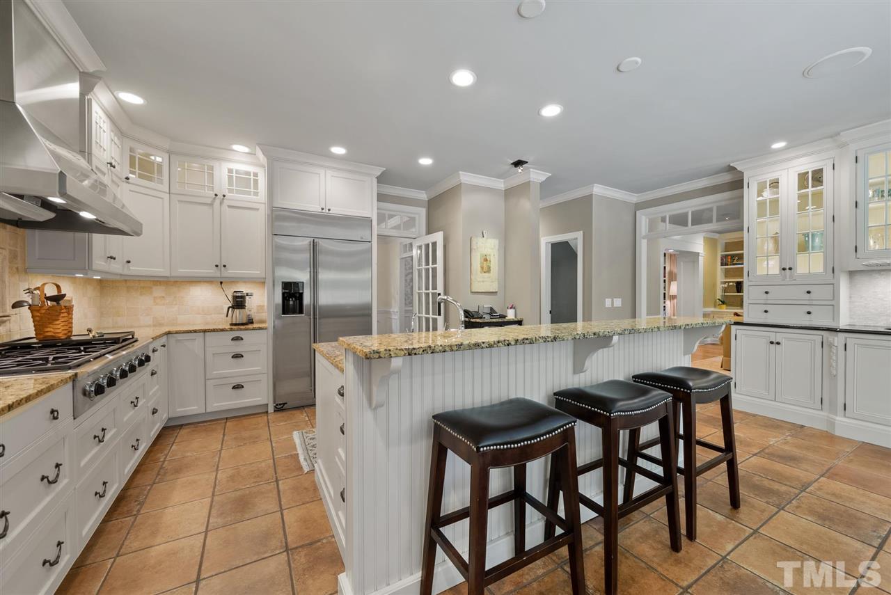 4028 John S Raboteau Wynd Raleigh, NC 27612 - Photo 11 of 30 a kitchen with stainless steel appliances kitchen island granite countertop a sink and cabinets