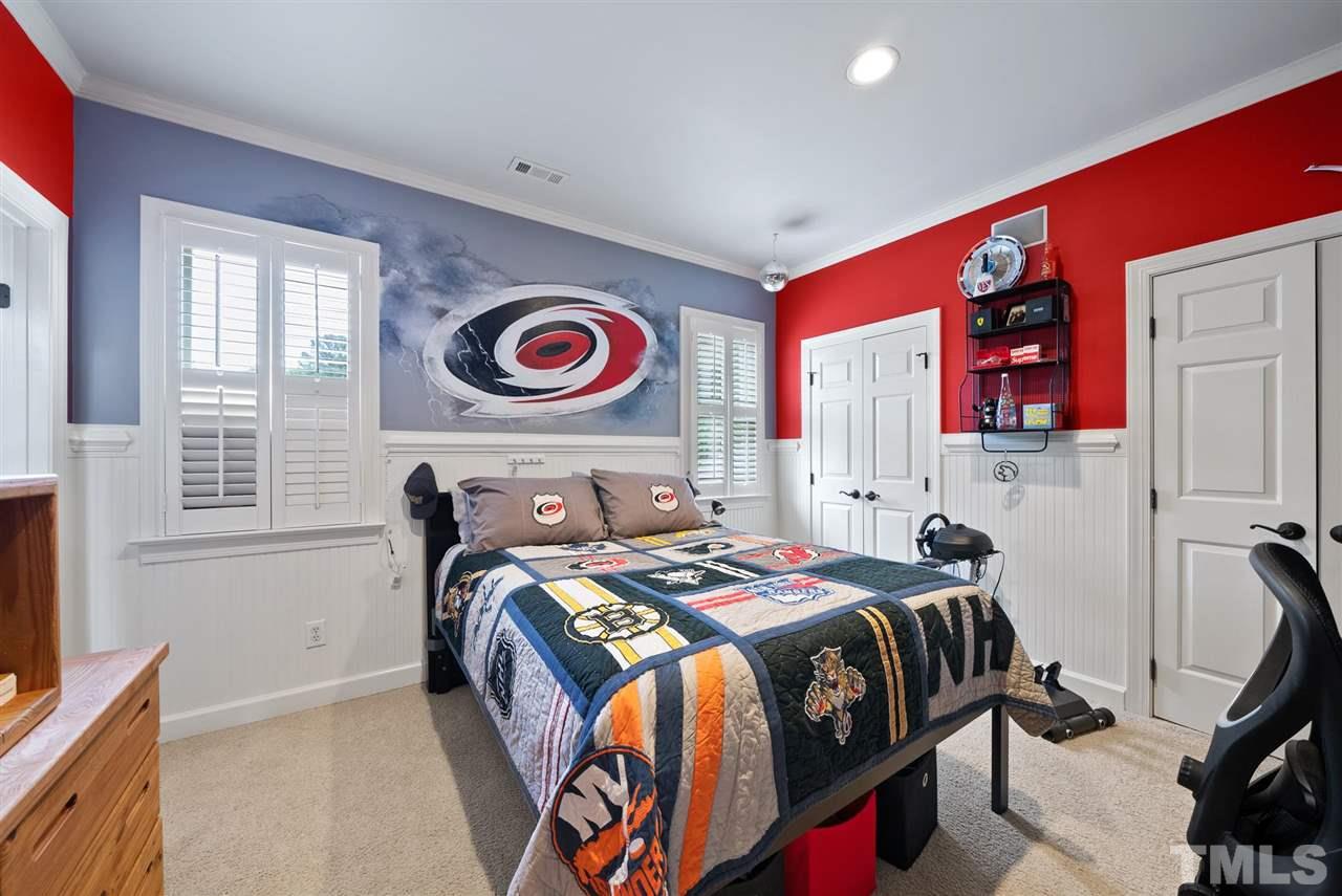 4028 John S Raboteau Wynd Raleigh, NC 27612 - Photo 20 of 30 a bedroom with a bed and wooden floor