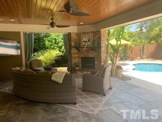 4028 John S Raboteau Wynd Raleigh, NC 27612 - Photo 25 of 30 a living room with patio furniture and a fireplace