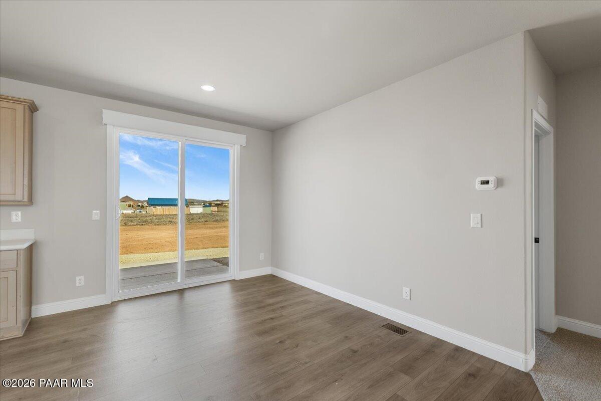 7366 East Bunkhouse Road Prescott Valley, AZ 86315 - Photo 12 of 25 an empty room with wooden floor and windows